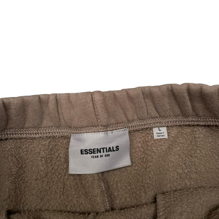 Essentials brown jogger shorts with logo detail and soft cotton material.