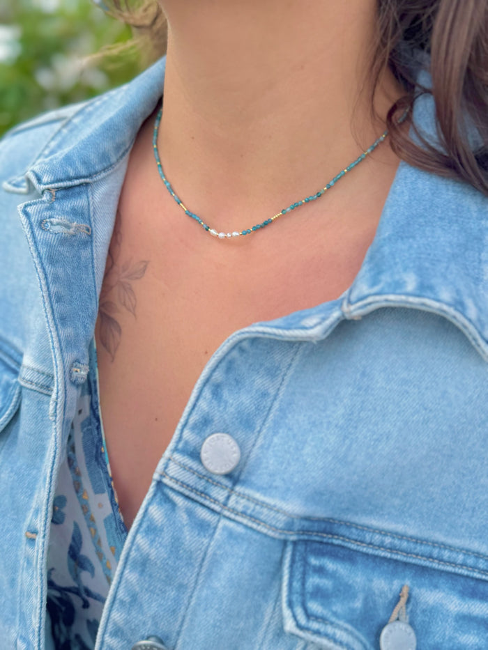 Model wearing Apatite Stainless Steel Necklace featuring sea-toned apatite beads with a freshwater pearl center detail.