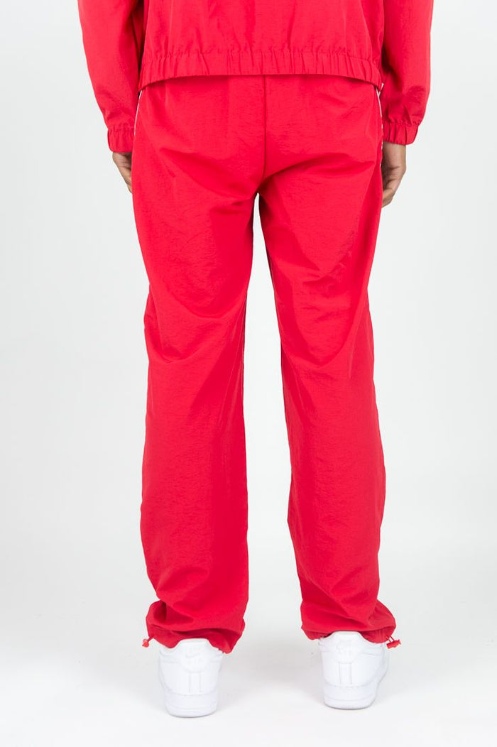 Red Rebel Minds Bent Stripes nylon sweatpants with white stripe details, comfortable athletic joggers for casual wear.
