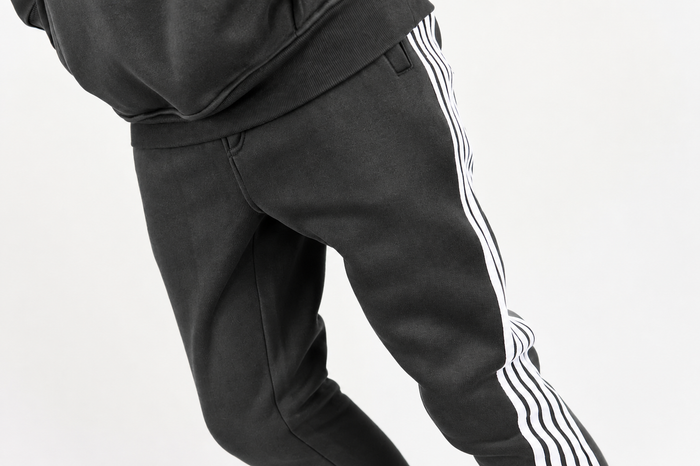 Rebel Minds Five Stripes stacked grey and white sweatpants with a relaxed fit, featuring bold stripe detailing on the legs.