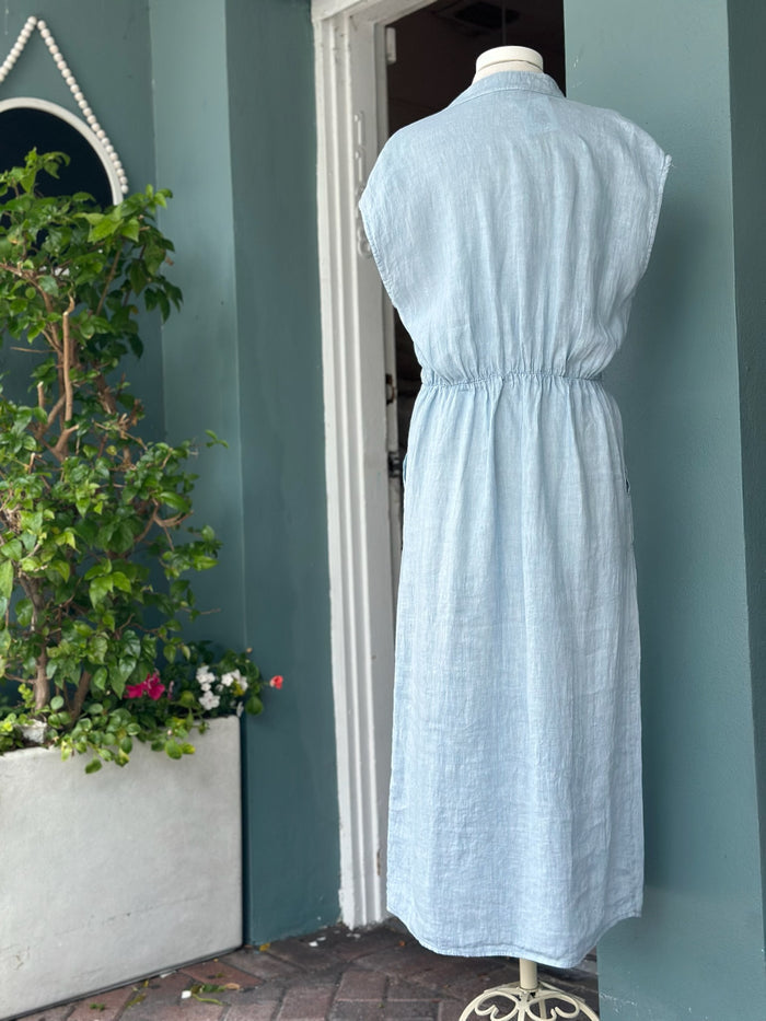 Back view of a sky blue linen midi dress featuring cap sleeves, an elasticized waist detail, and an easy, flowing silhouette in breathable linen.