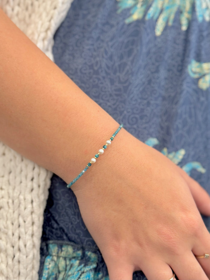 Model wearing Tessa Apatite and Miyuki Bead Bracelet featuring teal apatite beads, Miyuki accents, and a freshwater pearl center.