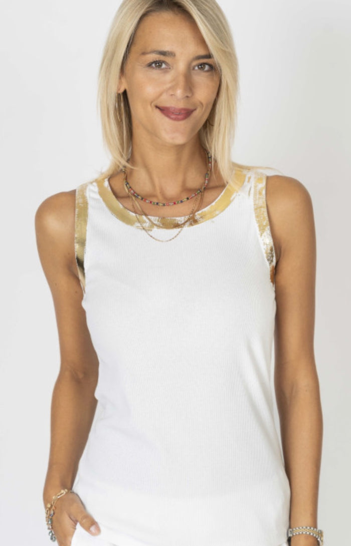 Woman wearing a white sleeveless top with gold trim. Made in Italy.