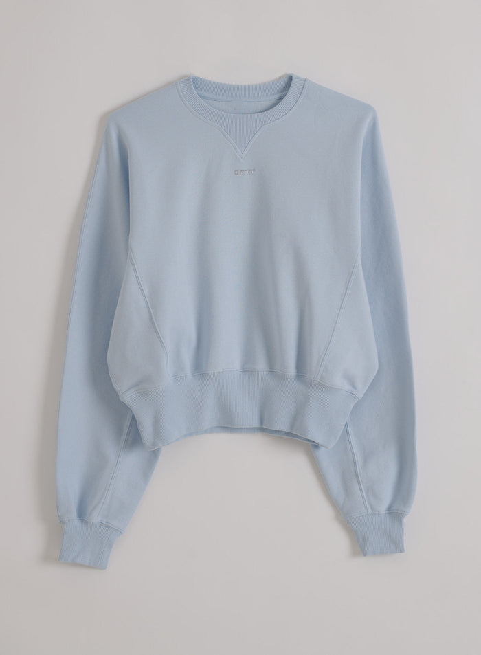 Vaaleansininen piqué-pintainen Aura Sportif Sweatshirt resoreilla ja hienovaraisella aim'n-logolla flatlay-kuvassa.