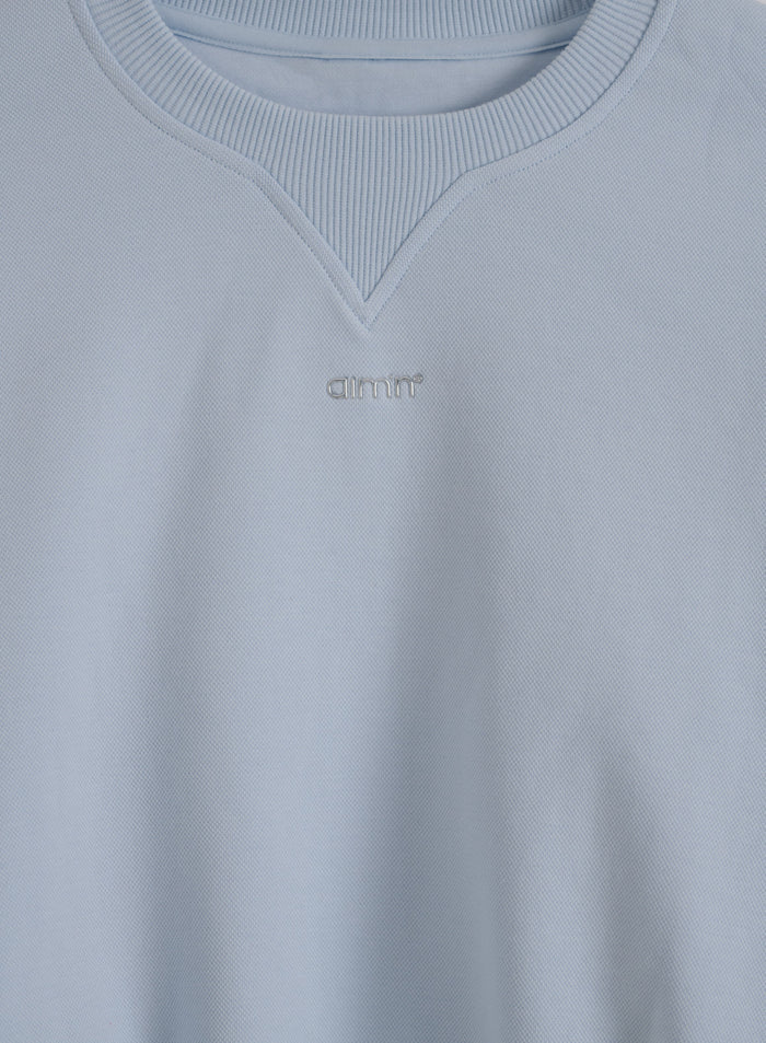 Vaaleansininen Aura Sportif Sweatshirt piqué-teksturoitua jerseytä ja metallinen aim'n-logo.