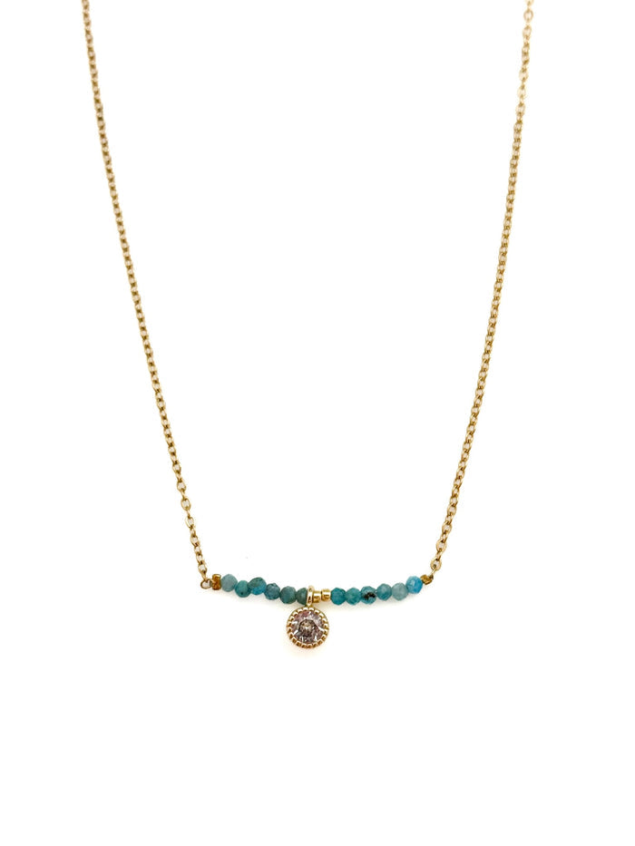 Ava Apatite Stainless Steel Necklace with gold-toned stainless steel chain, blue apatite bead bar, and crystal charm on white background.