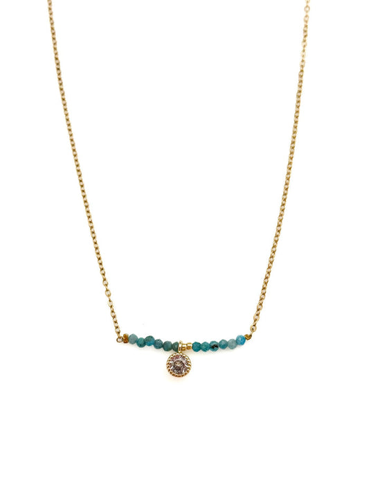 Ava Apatite Stainless Steel Necklace with gold-toned stainless steel chain, blue apatite bead bar, and crystal charm on white background.