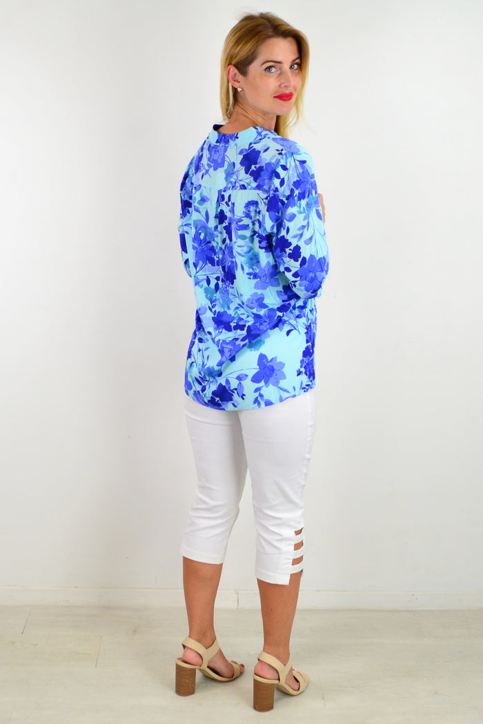 Blue floral tunic top from I Love Tunics featuring a vibrant pop of color and lightweight fabric, shown on a hanger.