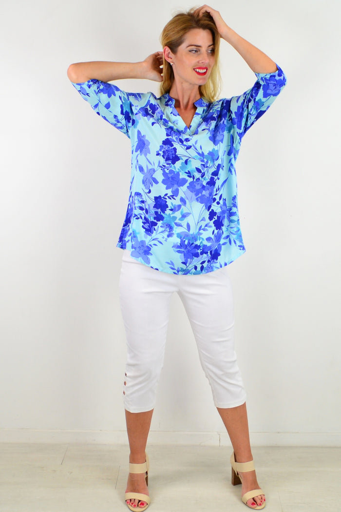 Blue floral tunic top from I Love Tunics with a vibrant pattern and relaxed fit, showcased on a hanger against a neutral background.