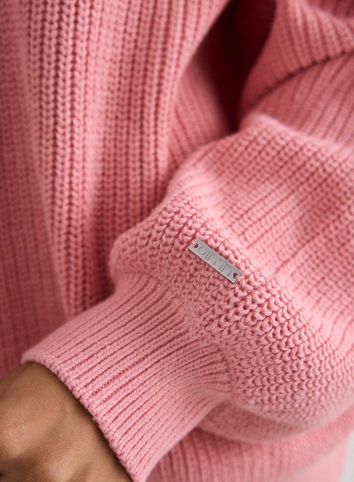 Lähikuva Blush Knitted Sweatshirt -paidan hihasta, jossa näkyy neuloksen tekstuuri ja aim'n-metallilogo [S-170cm]
