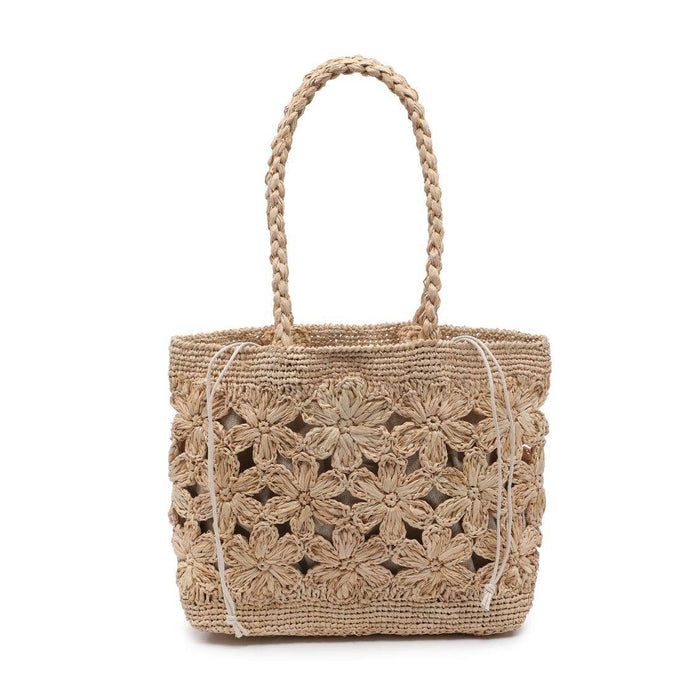 Natural woven tote bag featuring an open floral crochet design, braided shoulder straps, and a structured rectangular silhouette. Crafted in a natural raffia-style material with intricate flower detailing and a lightweight, beach-inspired look.