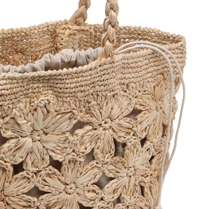 Interior of the Briar Tote in natural woven raffia-style material, featuring a removable natural linen drawstring pouch for added organization and secure storage. The soft linen lining complements the floral crochet exterior while keeping essentials tucked away.