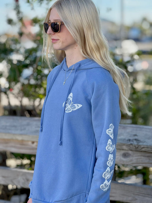 Women’s butterfly pullover hoodie with chest butterfly graphic, butterfly sleeve design, drawstring hood and ribbed trim at Ardor Boutique.