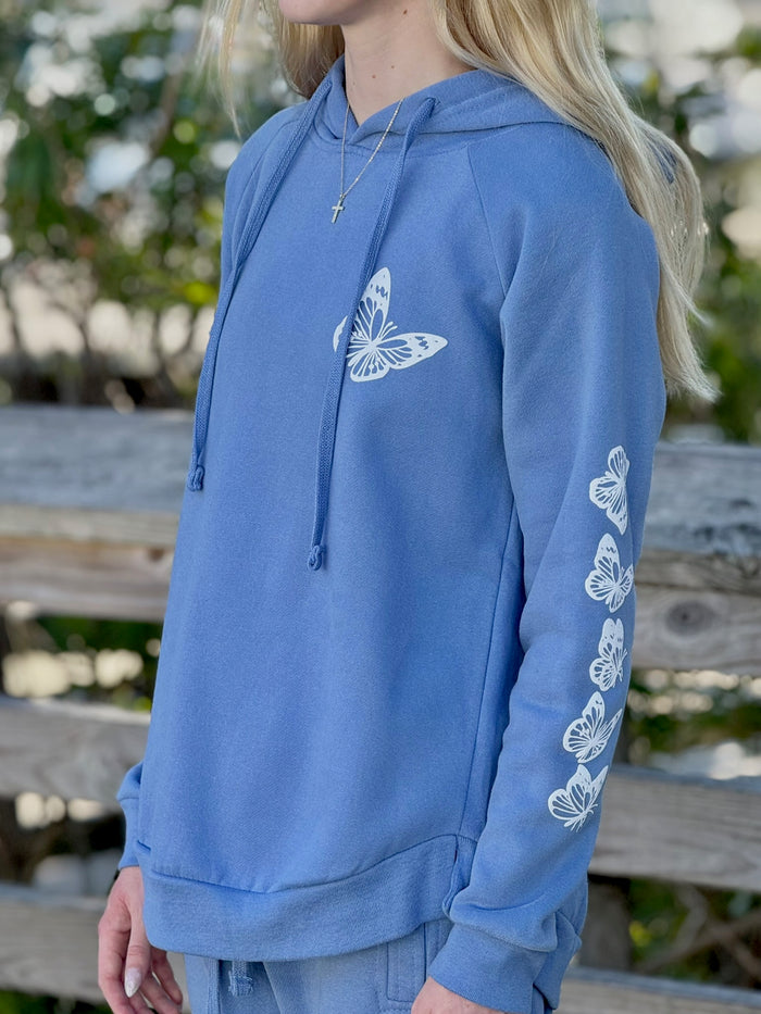 Women’s butterfly pullover hoodie with chest butterfly graphic, butterfly sleeve design, drawstring hood and ribbed trim at Ardor Boutique.