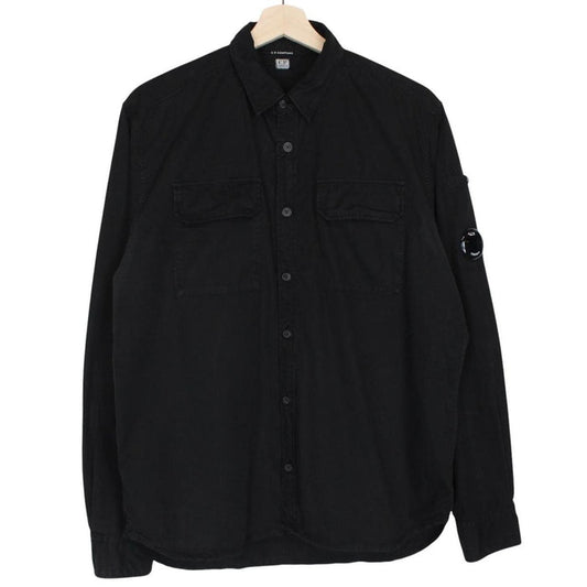 CP Company black button-up jacket with lens detail and cotton material.