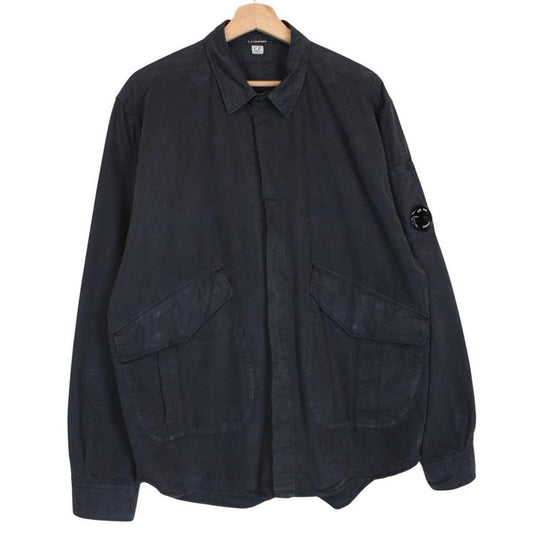 CP Company navy blue overshirt jacket with diamond pattern and lens detail.