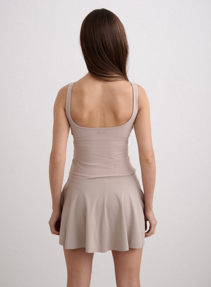 Tummanbeige Sense Singlet avoimella selällä ja yhteensopiva hame merkiltä aim'n. [XS-174cm]