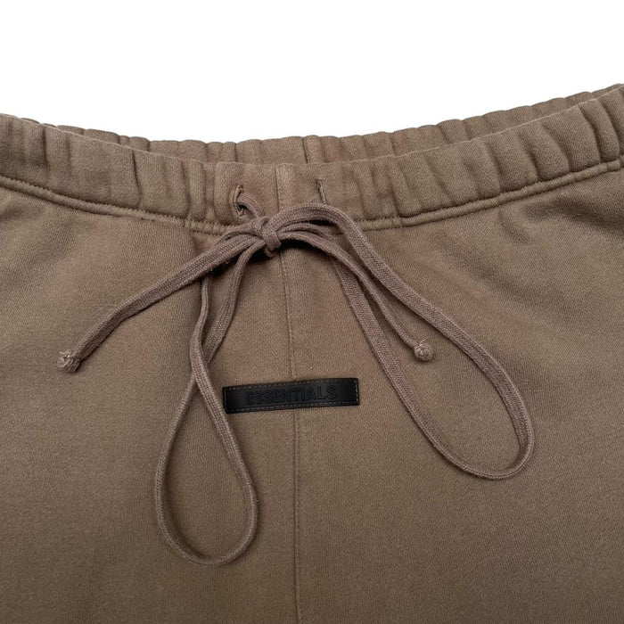 Essentials brown jogger shorts with logo detail and soft cotton material.