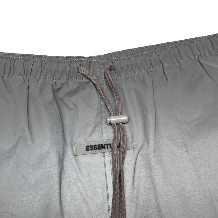 Essentials silver reflective nylon shorts with logo detail and sleek design.