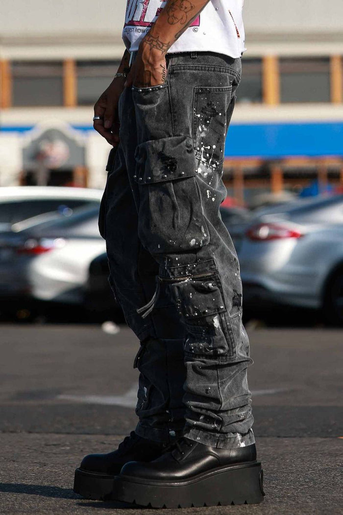 First Row black slim fit cargo denim jeans with stud details, showcasing front view and pocket design.