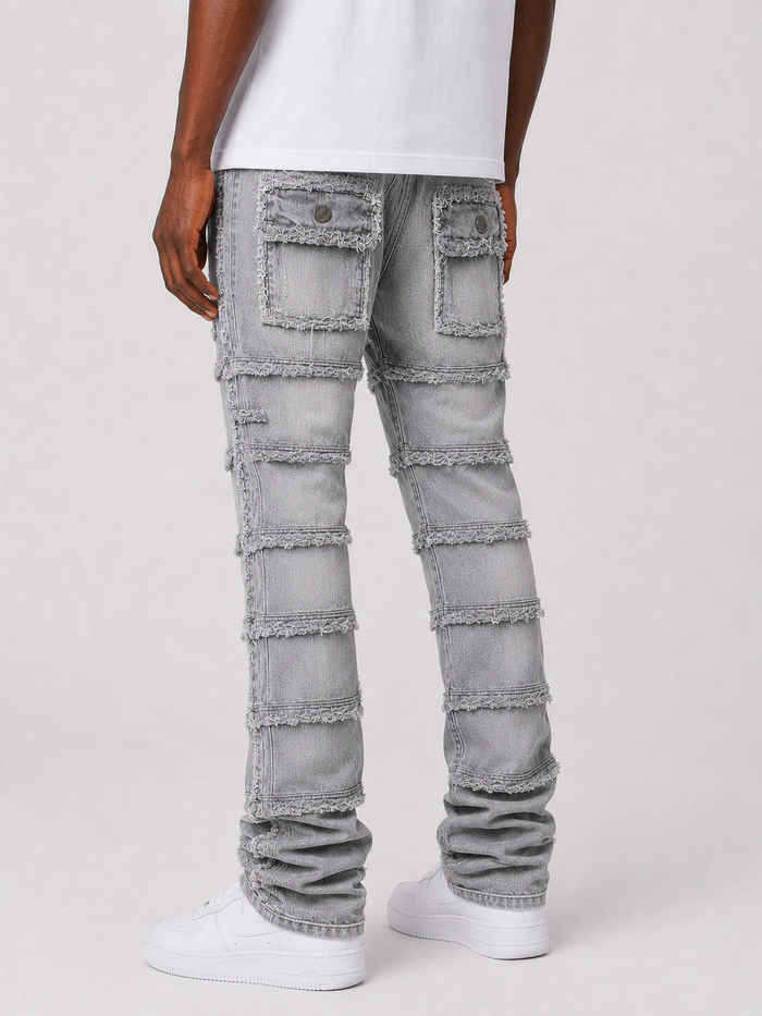 FWRD Patchwork True Stacked Denim jeans in grey with layered patchwork design and stacked fit, displayed on a model.