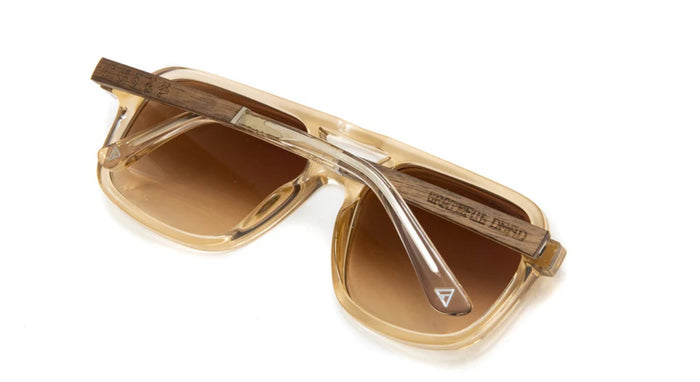Back view of Camp Eyewear Grateful Dead Forever sunglasses highlighting engraved walnut wood temples, translucent champagne frame, and brown gradient polarized lenses.