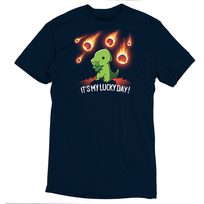 Premium Cotton T-shirt_TeeTurtle navy blue It's My Lucky Day featuring a dinosaur holding a four-leaf clover while meteors fall from the sky. The text below reads, "It's my lucky day!".