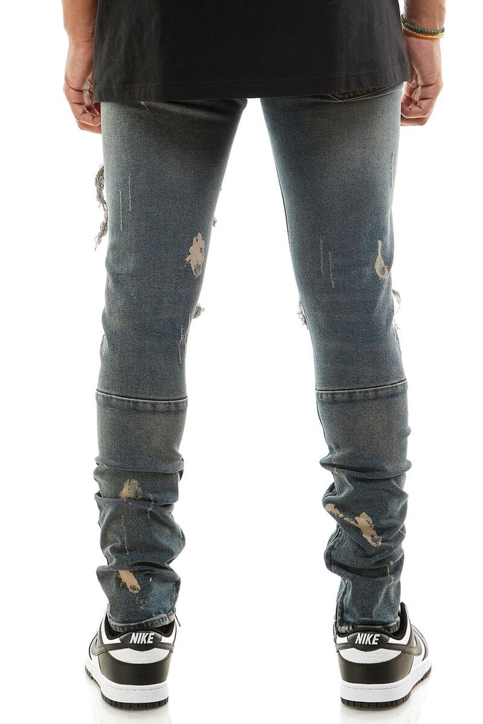 KDNK Destroyed Knee Ankle Zip Denim in steel blue, showcasing distressed denim style with zip detail at the ankle.