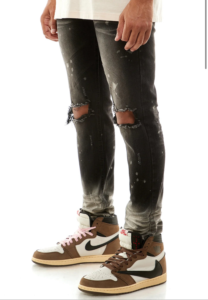 KDNK ombre bleached black denim jeans with distressed details, slim fit style, showcasing the fabric texture and fading design.