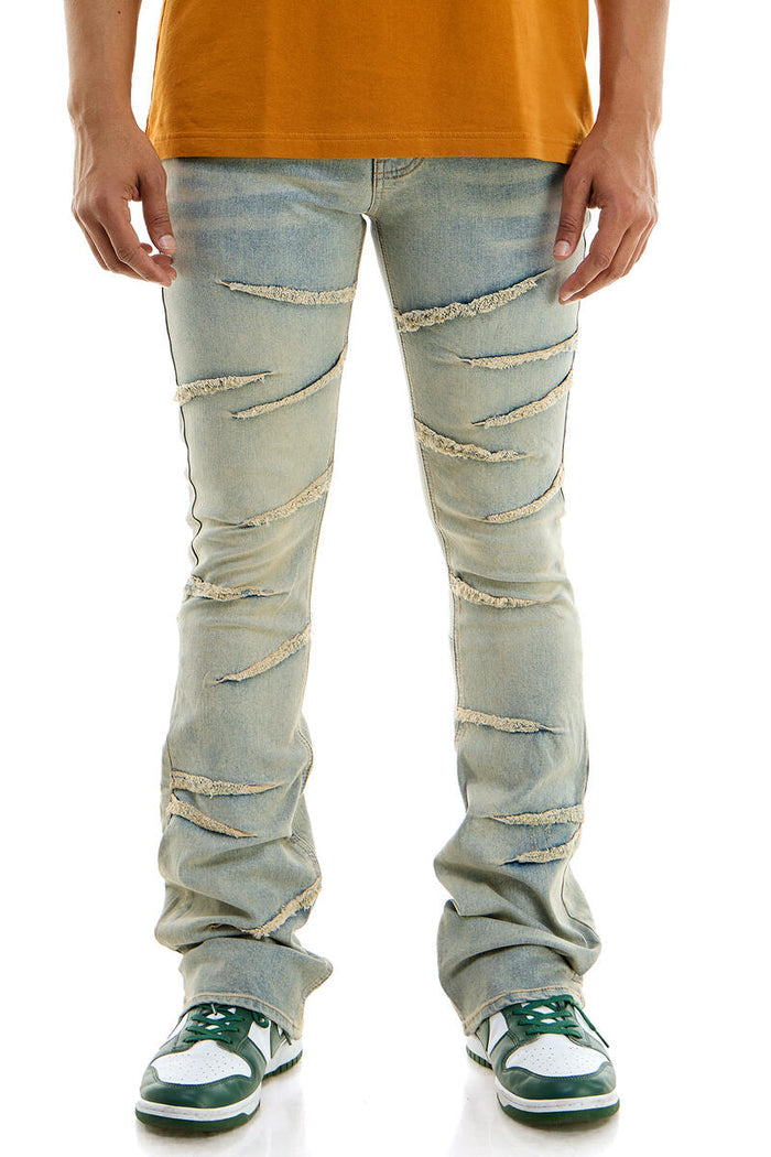 Blue KDNK Raw Edge Skinny Flare Denim jeans with distressed hem and fitted silhouette, styled on a model.