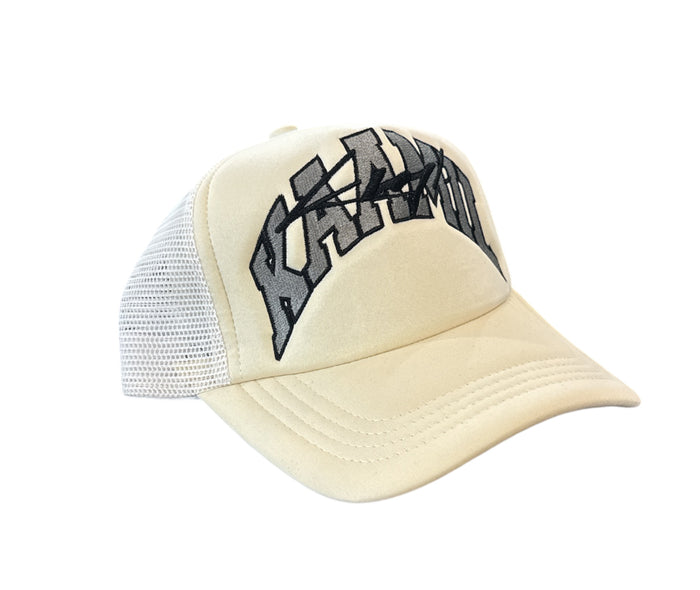 Cream KML ‘ARC’ Trucker Hat by KAAMIL with mesh back and curved brim, stylish casual headwear.