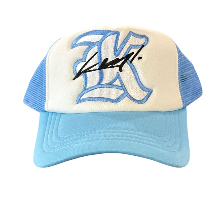 White and Carolina blue KML ‘K’ Trucker Hat by KAAMIL with mesh back and adjustable strap, casual style accessory.