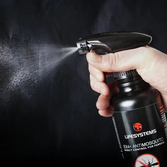 Person spraying Lifesystems EX4 Insect Repellent from its 350ml bottle against a dark background