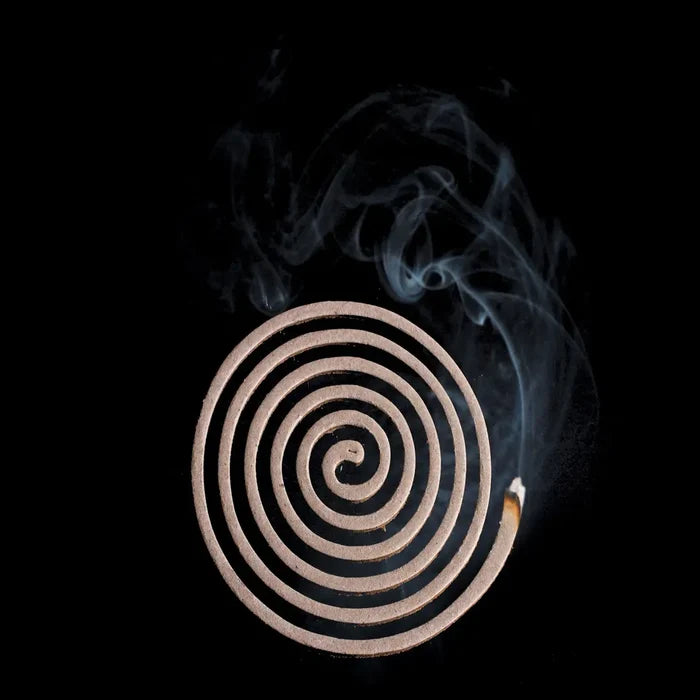 Lit single Lifesystems insect repellent coil showing the smoke production on a black background