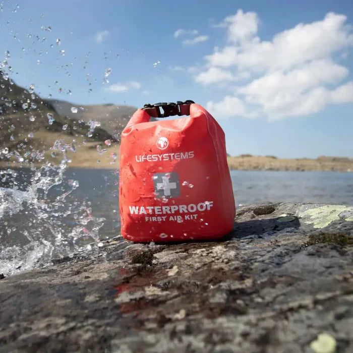 Lifesystems Waterproof First Aid Kit on rocks being splashed by waves