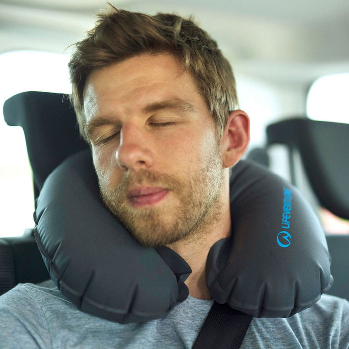 Man using a Lifeventure inflatable neck pillow in the car when sleeping