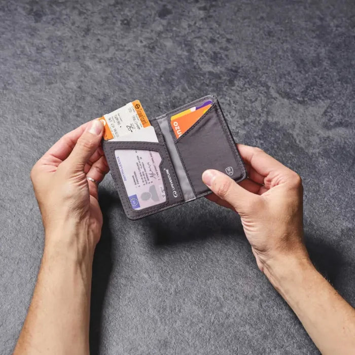 Person holding an open Lifeventure RFID card wallet with cards on a grey background