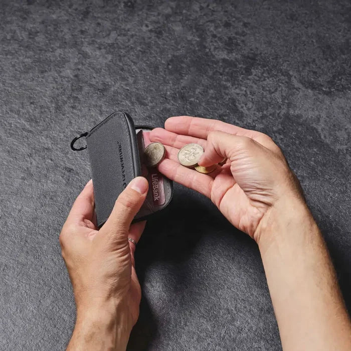 Lifetyle image of a person placing money into a Lifeventure coin wallet