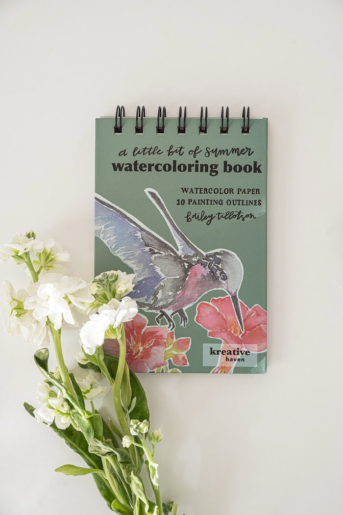 Watercolor book with a hummingbird illustration on a white background