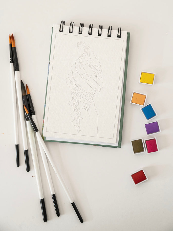 Set of watercolor brushes and color swatches on a white surface
