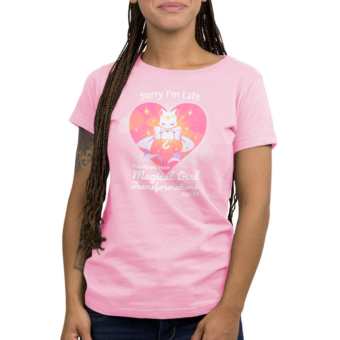 Premium Cotton T-shirt_TeeTurtle light pink Magical Girl Transformations apparel featuring a cat floating in a heart with a large bow and sparkles like classic anime girl. Captions says, "Sorry I'm late, you know how magical girl transformations can be".
