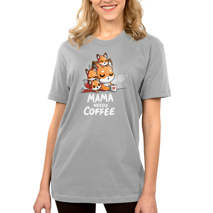 Premium Cotton T-shirt_TeeTurtle- Mama Needs Coffee Silver Gray t-shirt featuring illustration of a tired fox holding a coffee mug on gray background, with three small foxes climbing on her.