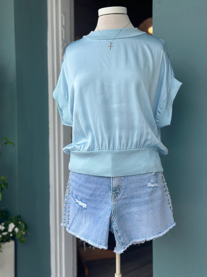 Light blue Mara Italian Washable Silk Top with a relaxed draped silhouette, ribbed trim, and soft, polished finish.