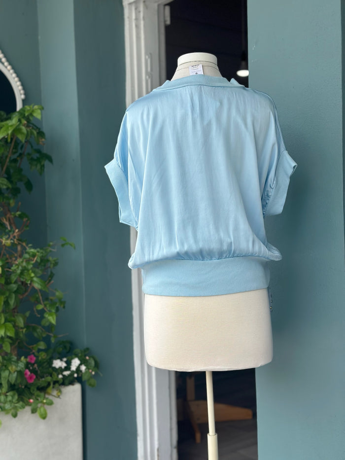 Back view of the light blue Mara Italian Washable Silk Top featuring a relaxed fit, lightweight washable silk fabric, and ribbed hem detail.
