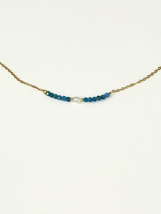 Blue apatite bead and freshwater pearl bar necklace on a gold-tone stainless steel chain, photographed on a white background.