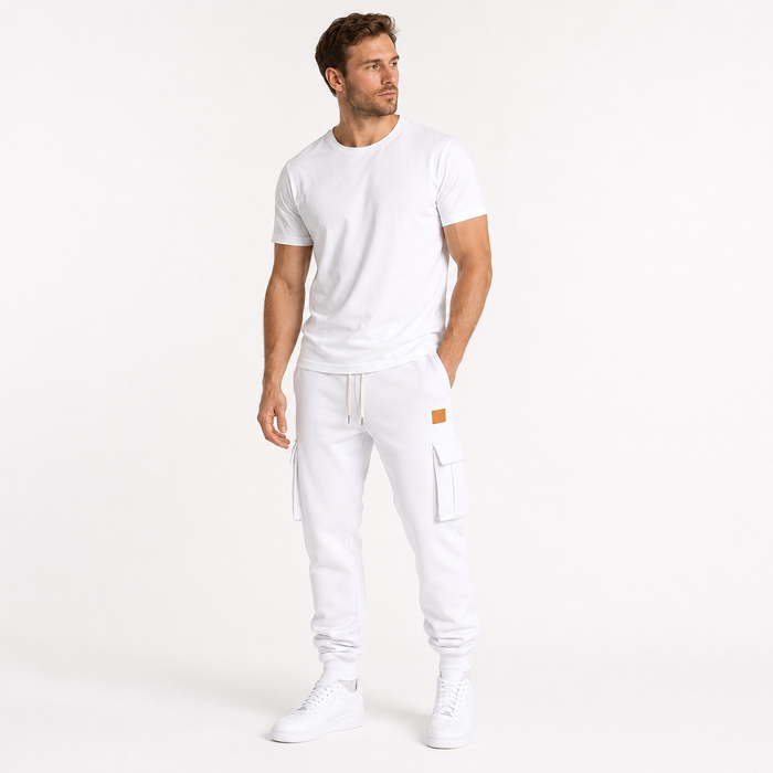 Male model wearing white cargo jogger pants in a minimalist lifestyle pose on a clean white studio background.