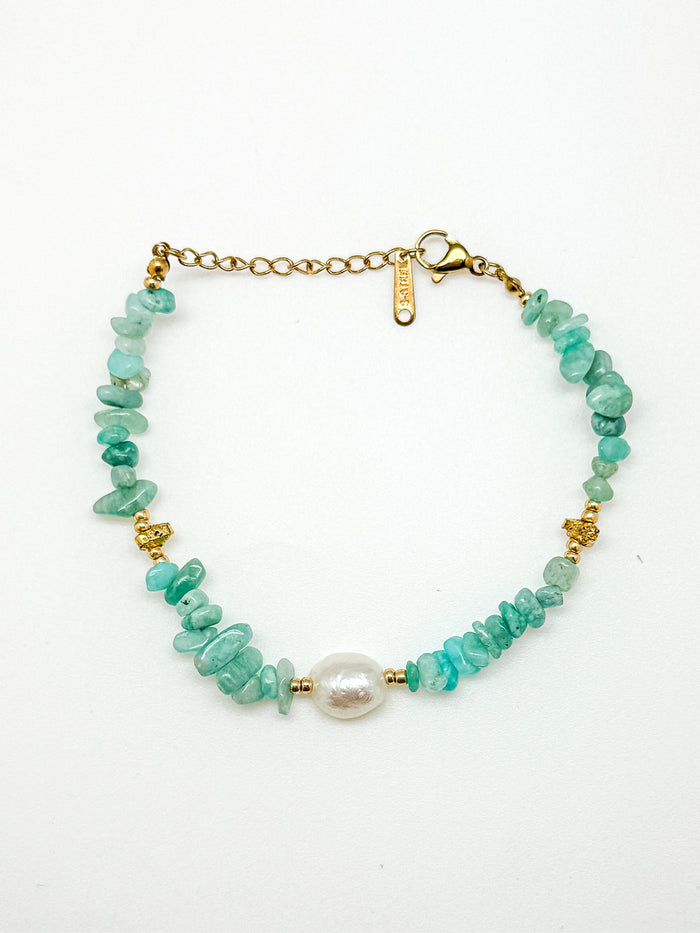 Bracelet with turquoise beads and a pearl on a white background