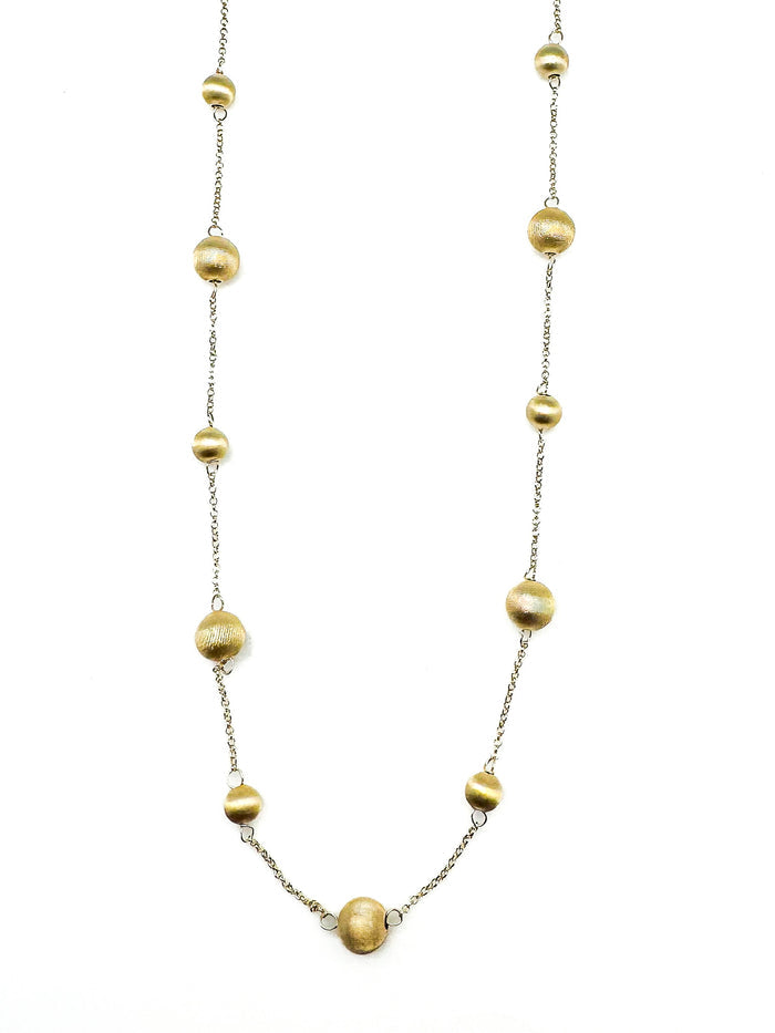Gold plated sterling silver bead station necklace photographed on a white background