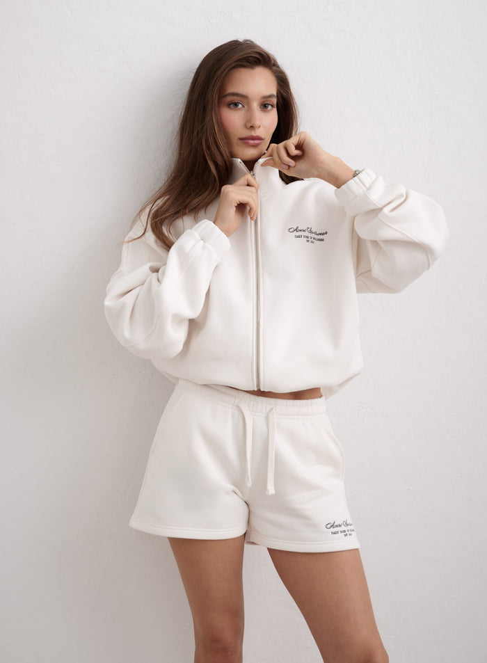 Luonnonvalkoiset Script Sweat Shorts -collegeshortsit ja niihin sopiva aim'n-vetoketjutakki. [XS-174cm]