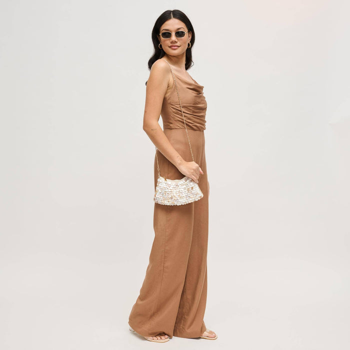 Model wearing the Opalite Evening Bag as a crossbody with a removable gold-tone chain strap, showcasing its shimmering opalescent shell disc embellishments.